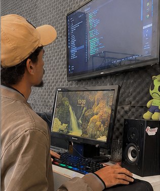 Filipe trabalhando no setup, entre dois monitores